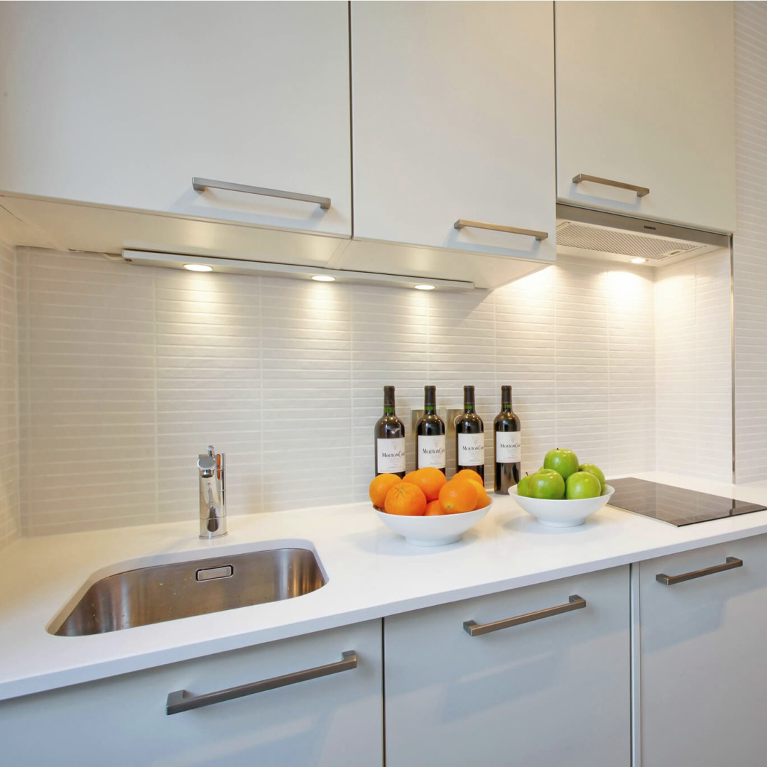 Paris apartment small modern kitchen with undermount sink, induction cooktop and flat front cabinets with stainless hardware - Hello Lovely Studio.