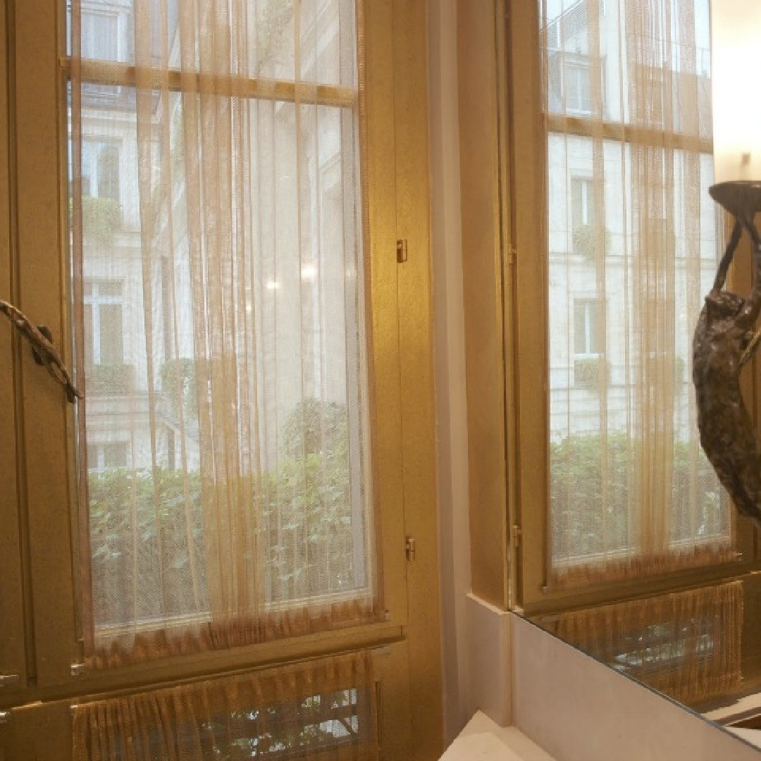 Gold leaf finish on windows and trim along with bronze sculptures and hardware by Rosaline Granet in our Park Hyatt Paris Vendome hotel suite - Hello Lovely Studio.