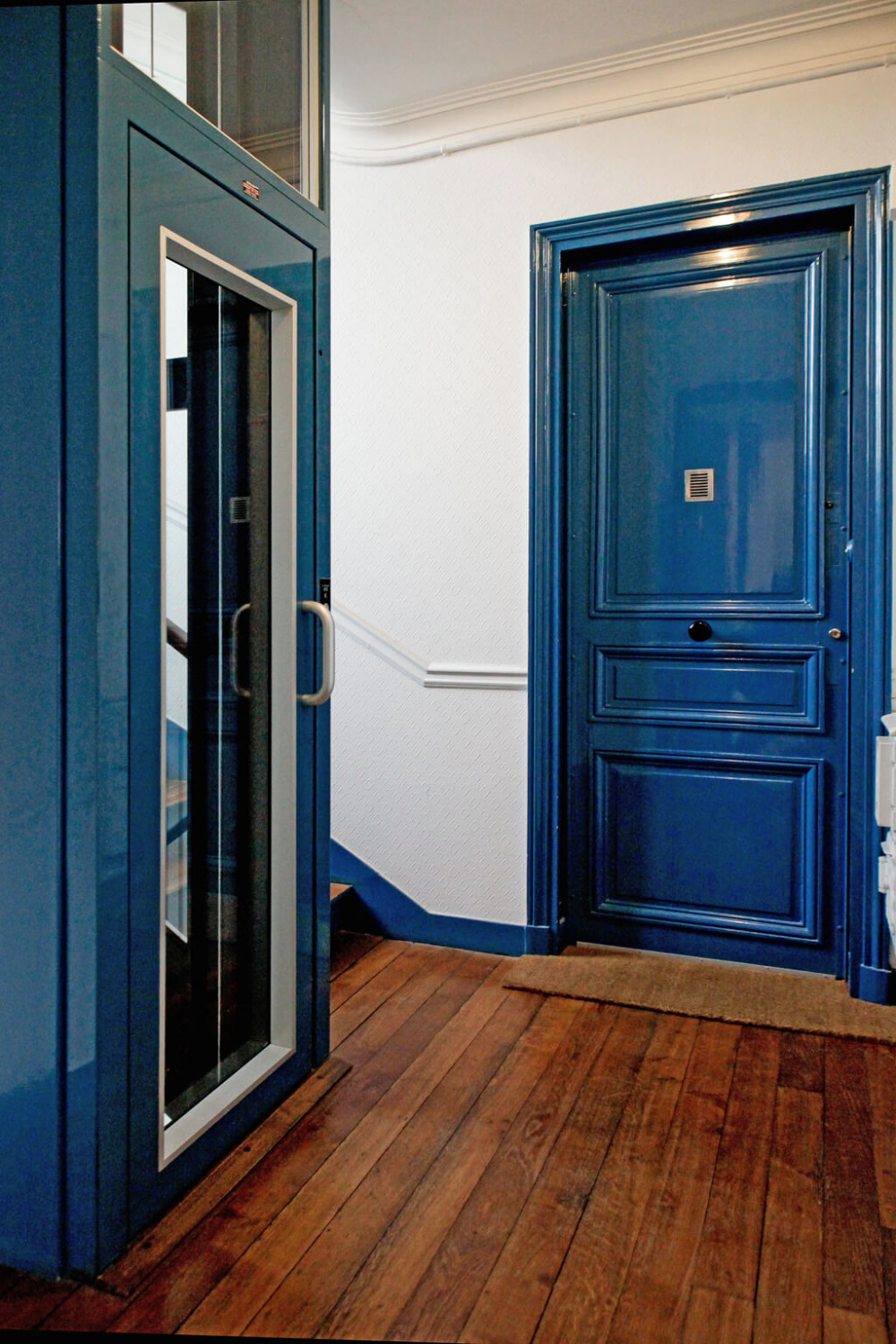 High gloss royal blue trim and doors in a Paris apartment building with elevator - Hello Lovely Studio.
