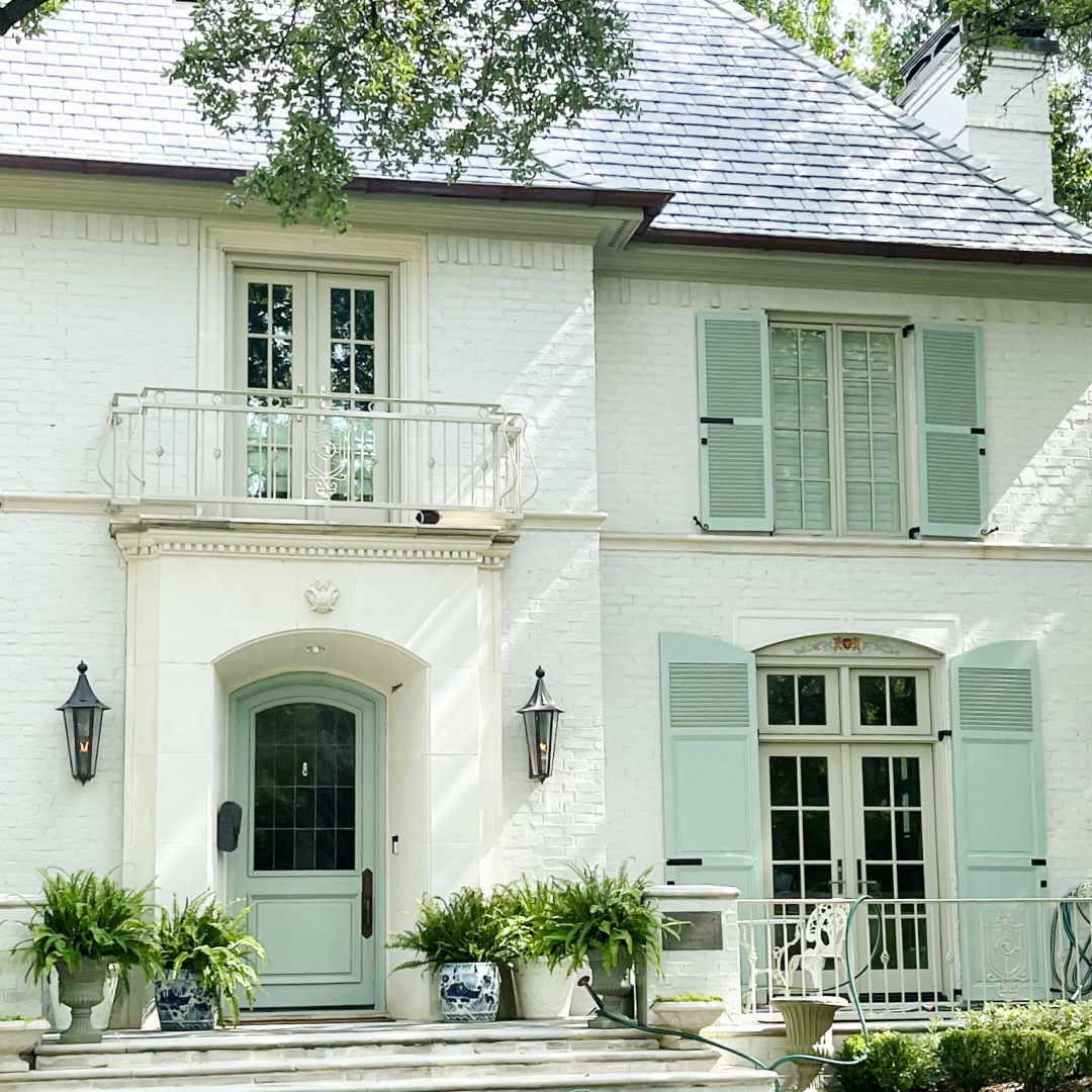 Benjamin Moore Raindance aqua shutters and door on white brick house exterior - The Potted Boxwood. #benjaminmooreraindance