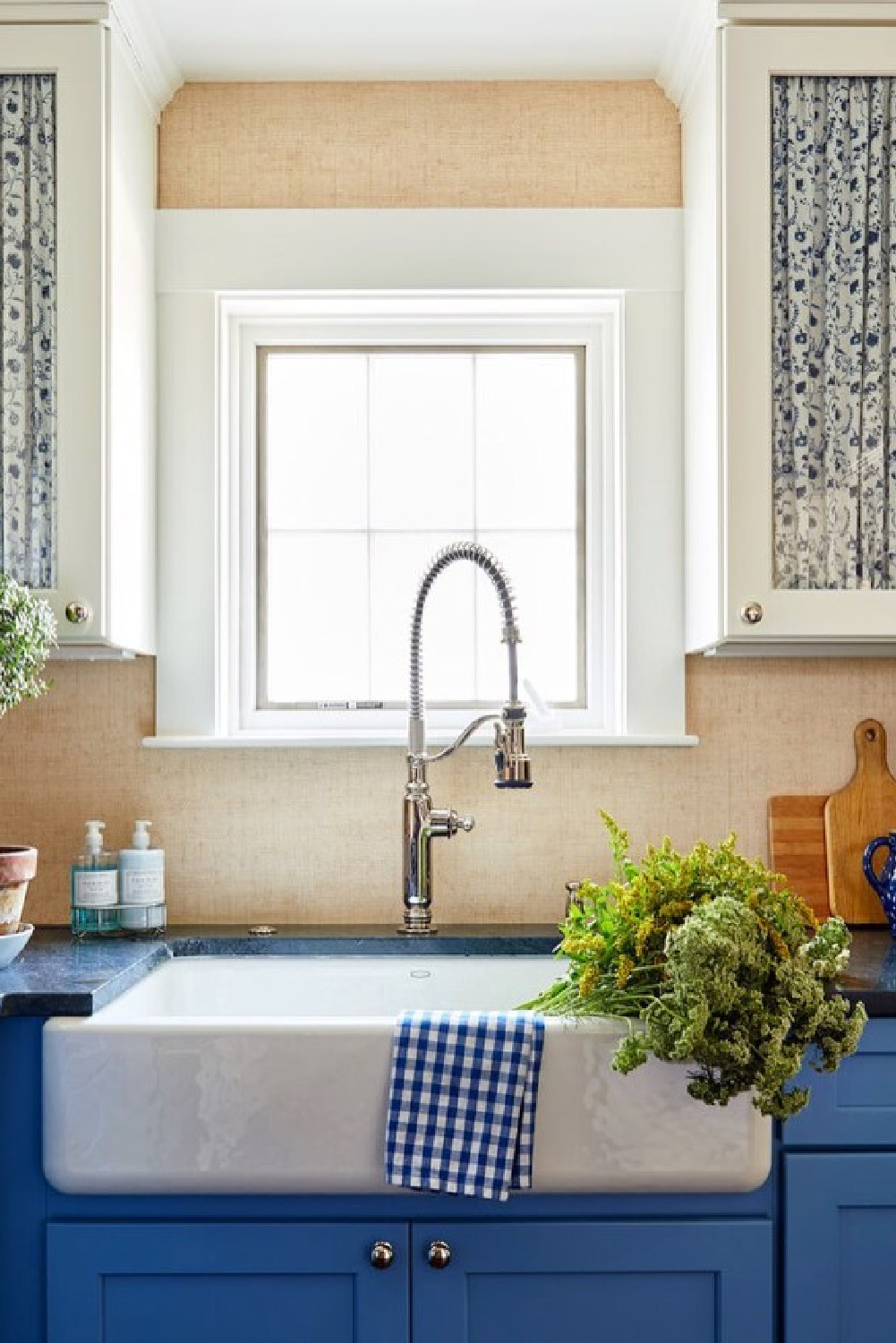 Blue base cabinets in kitchen with white uppers and fabric fronts - @lilsemckenna in House Beautiful.