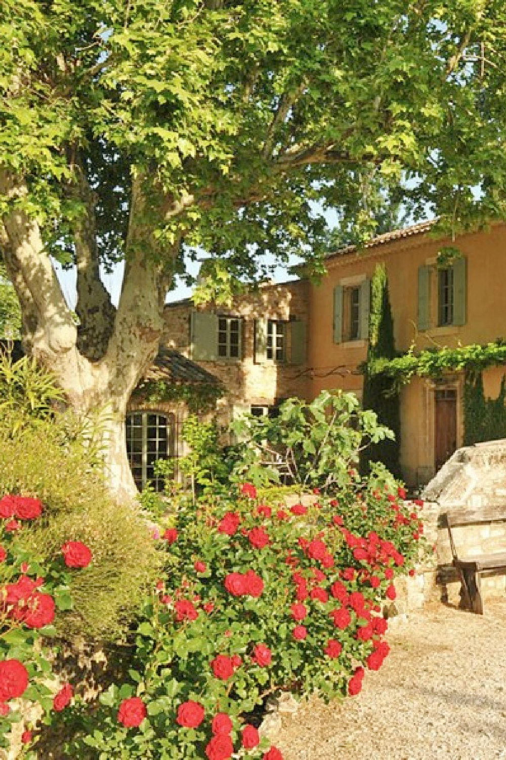 Beautiful French farmhouse exterior with yellow stucco and French blue shutters. Provence vacation rental Bonnieux Villa from Your Haven in Paris with lush gardens, romantic Old World rustic elegance.