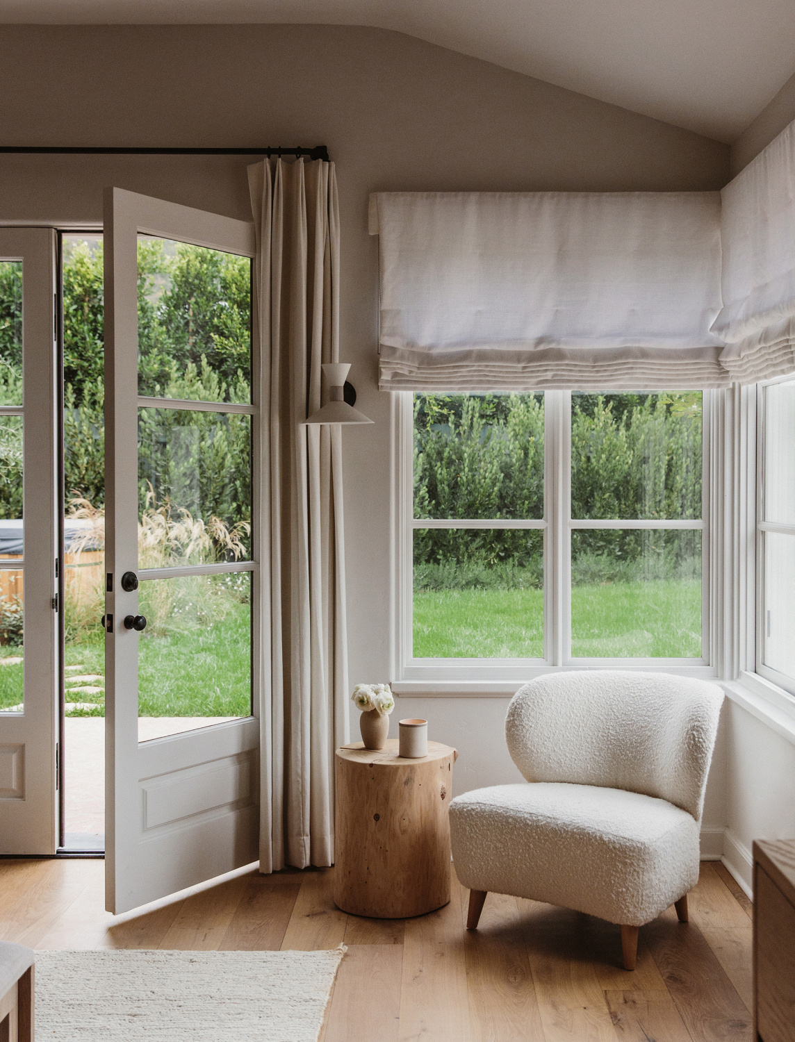 Serene neutral timeless reading nook with boucle chair and cedar chair - Jenni Kayne Home.
