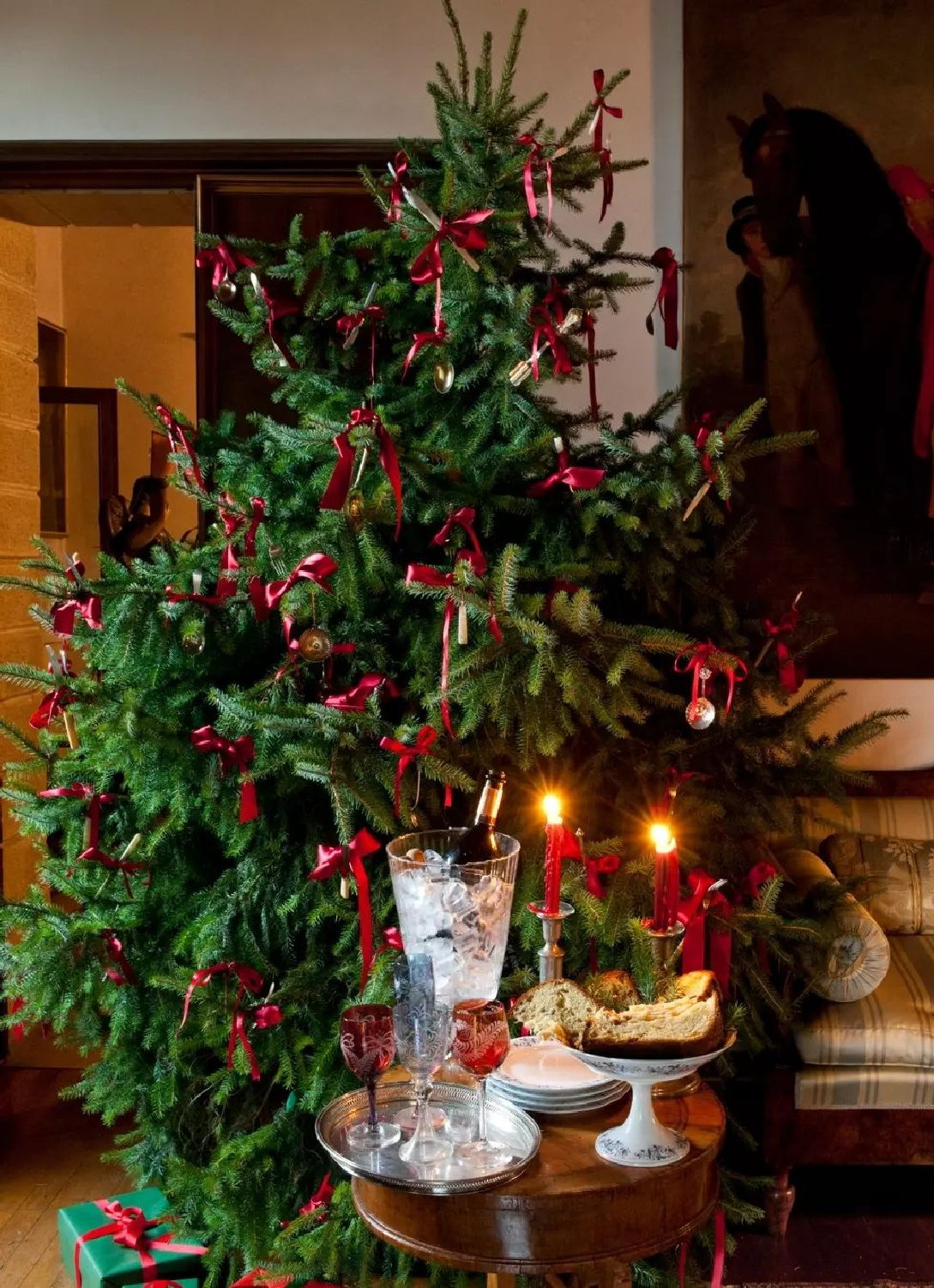 Lovely red ribbon Christmas tree decorations in a cozy traditional interior - @fredericmagazine. #christmastreedecor #elegantchristmas
