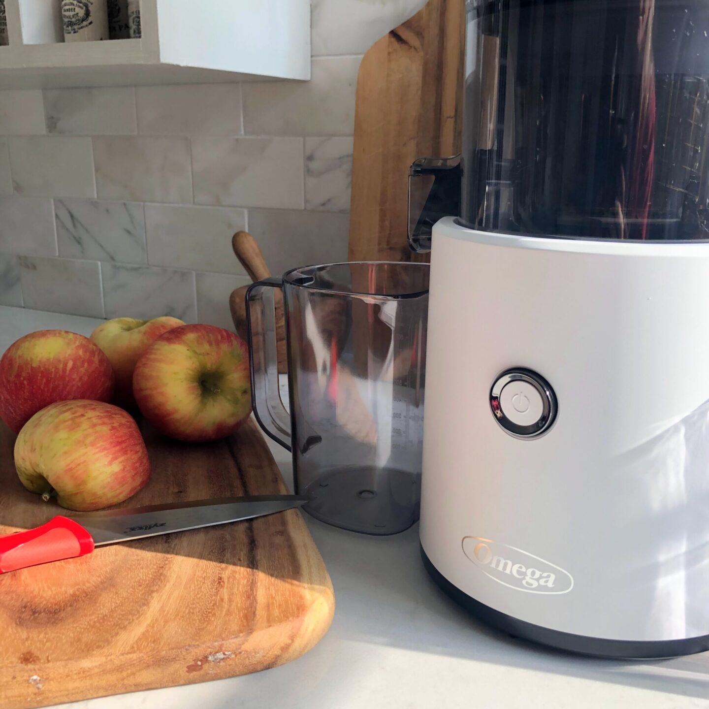 Omega Juicer (white) Effortless Series on my white quartz counter with apples - Hello Lovely Studio. #juicers #bestjuicers