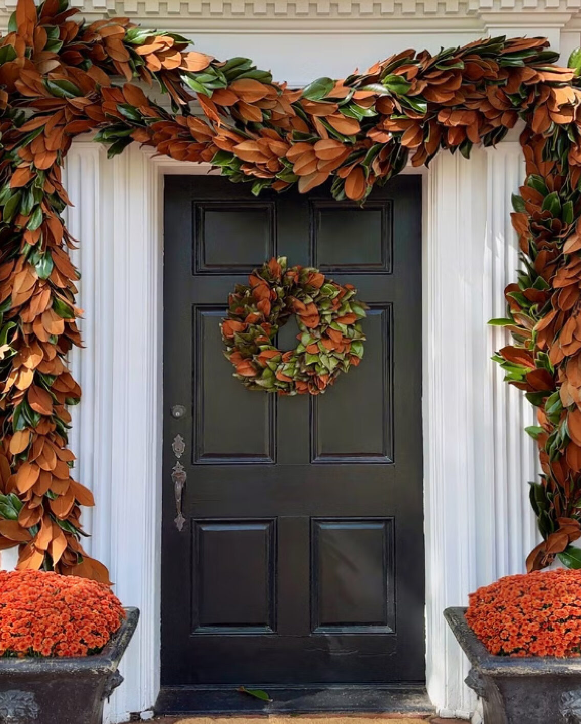 Magnolia garland and wreath on front door for holiday decor by Serena and Lily. #christmaswreaths #magnoliawreath #southernchristmas
