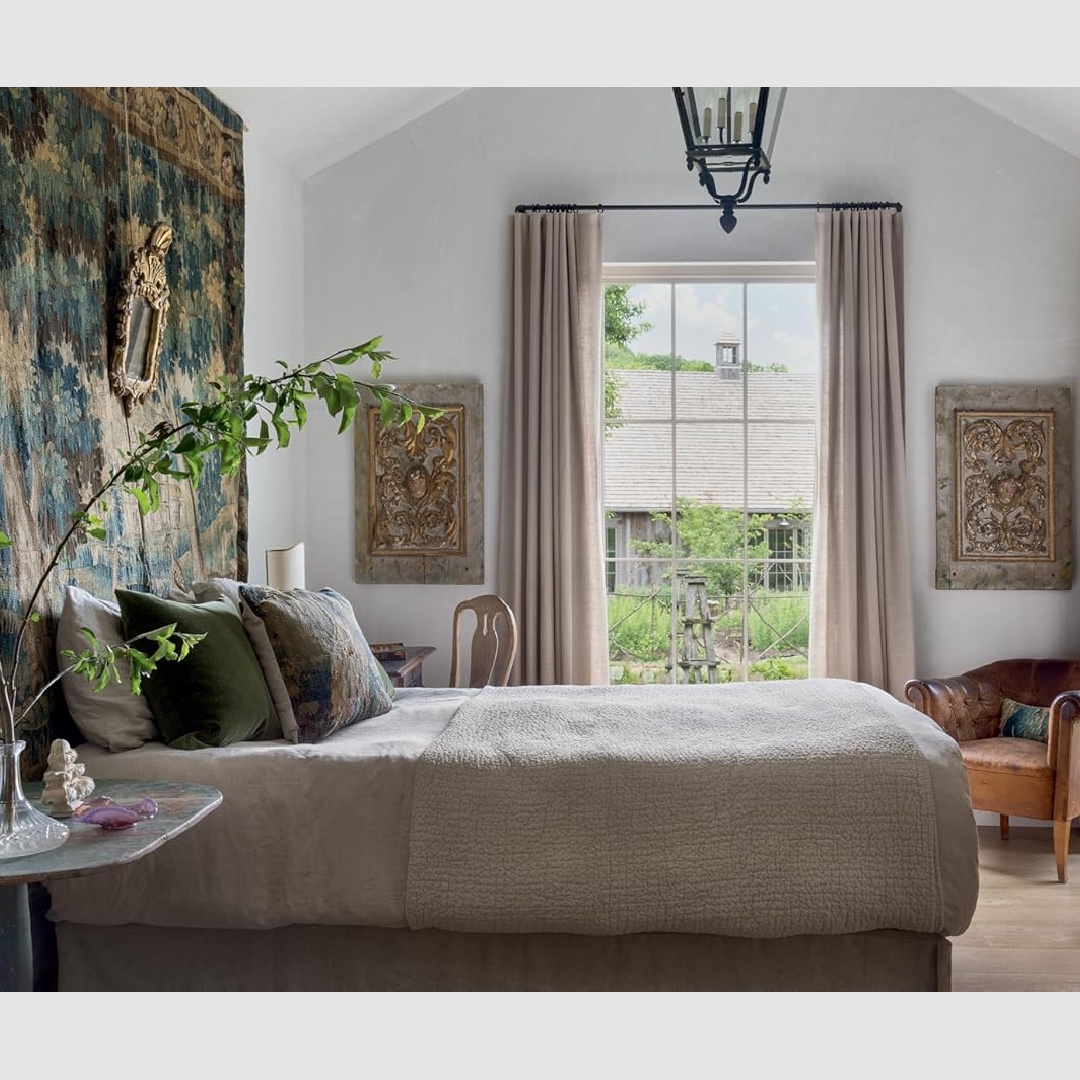 Bedroom with antique tapestry in a Tennessee log cabin. A beautiful interior from PATINA HOMES & GARDENS by Steve Giannetti & Brooke Giannetti.