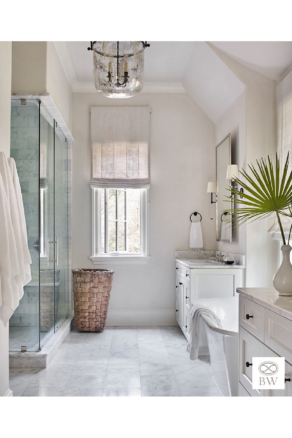 For her Sea Island project, a soaking tub rests between vanities in a luxe marble bath with timeless coastal style - Beth Webb Interiors.