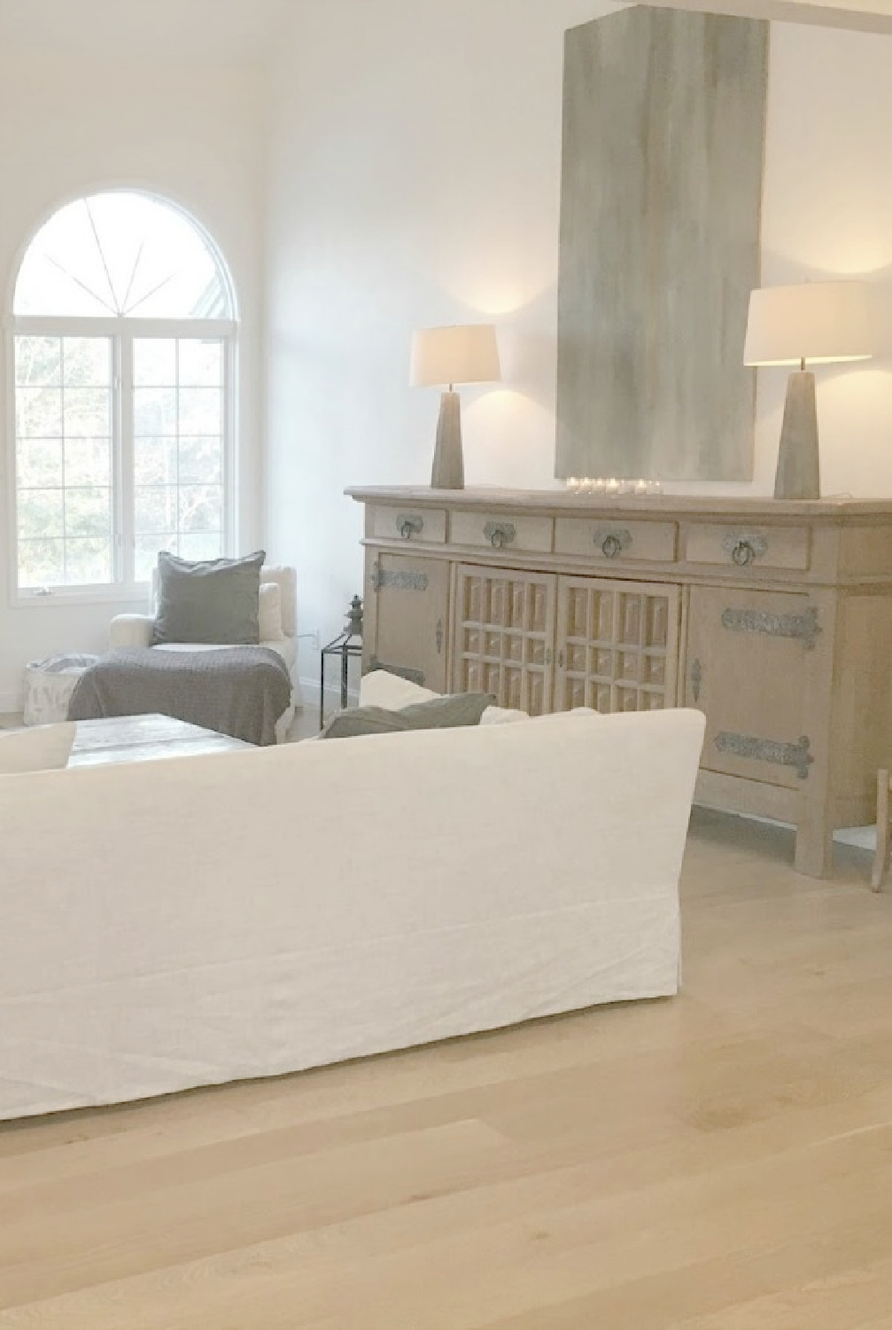 Hello Lovely's renovated European country living room with white oak hardwoods and rustic antique sideboard from Belgium.