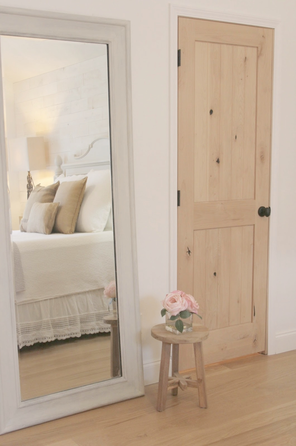 Hello Lovely's French country bedroom with white oak floors, rustic alder doors, and BM OC-151 white walls.