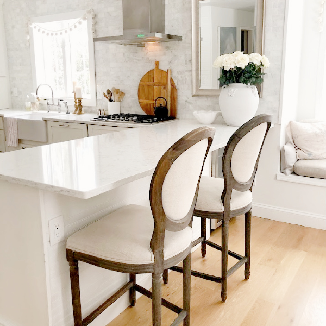Viatera Minuet countertops, polished Venatino marble backsplash, and white oak hardwoods in Hello Lovely's white Shaker kitchen.