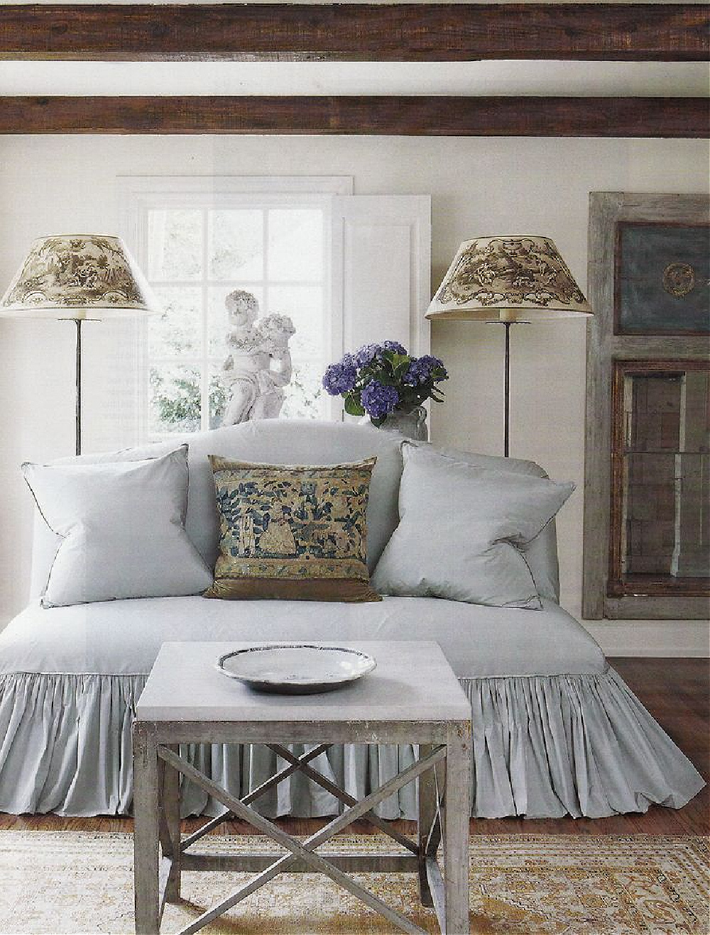 Shannon Bowers designed French country modern interior with ruffled settee and floor lamps.