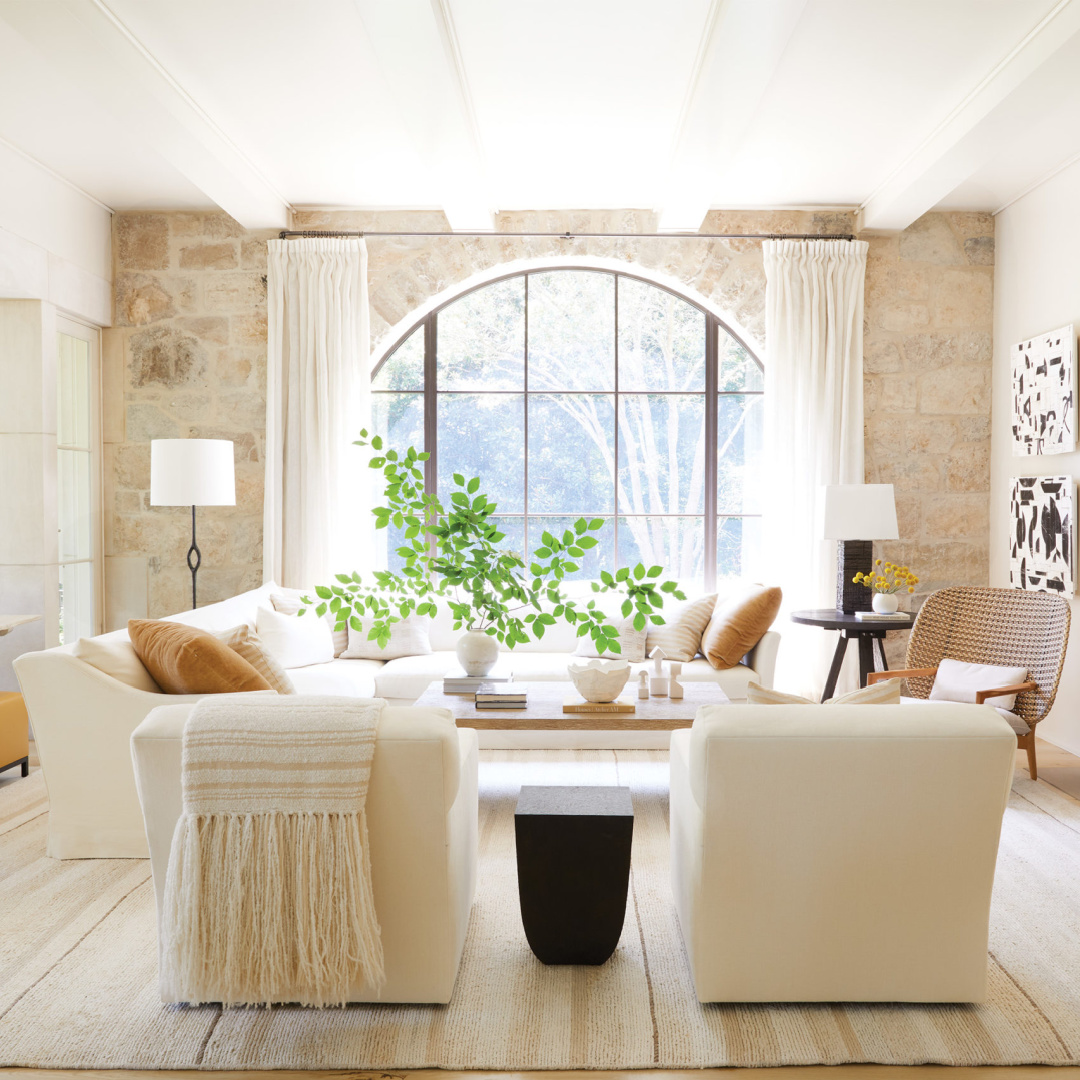 Suzanne Kasler designed living space with dramatic natural stone wall and arched window - in Frederic magazine.