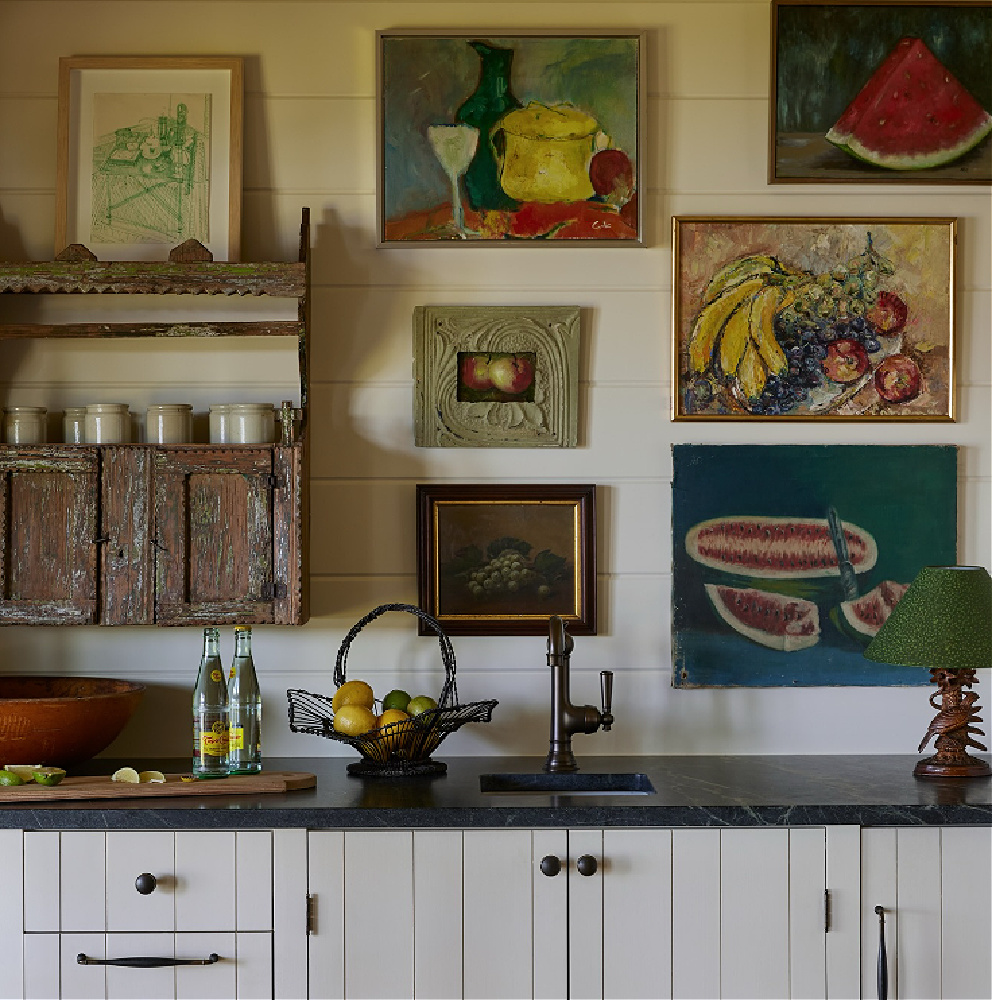 Shannon Bowers designed kitchen with gallery wall of beautiful vintage paintings.