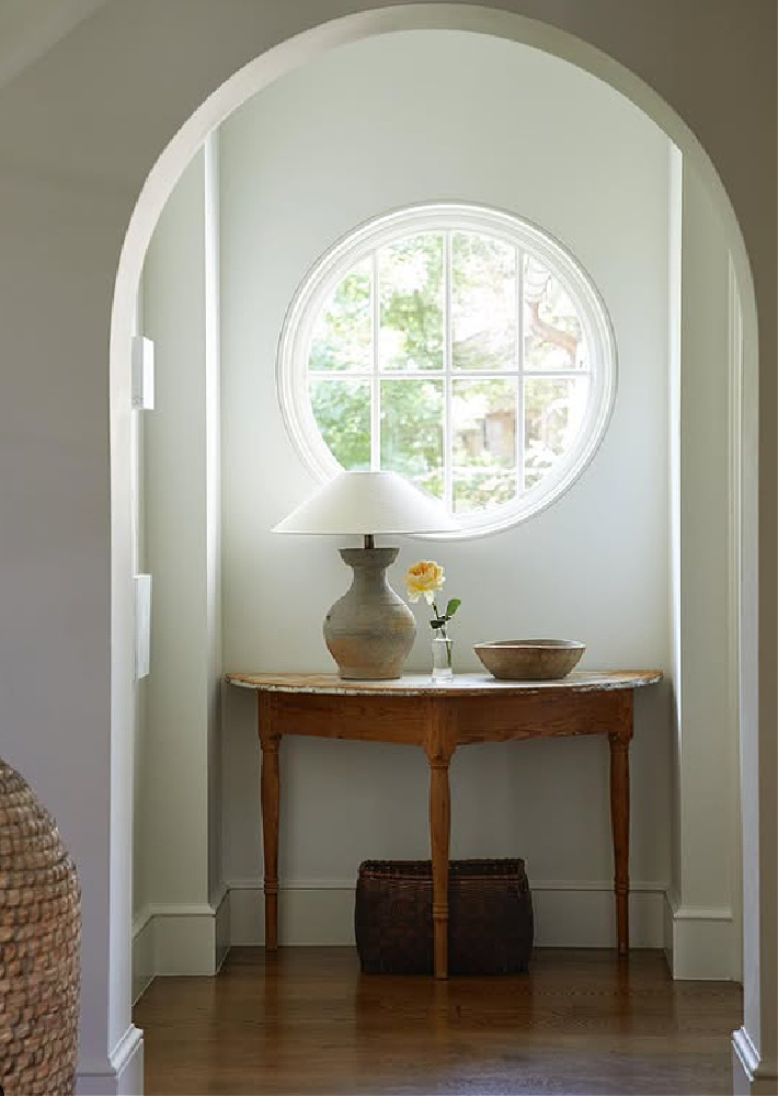 Shannon Bowers designed vignette with Belgian style lamp at demilune table and round window.
