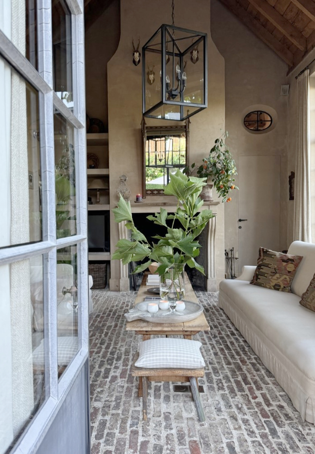 Brick flooring and elegant plaster walls in a Belgium home - Greet Lefèvre of Belgian Pearls. #belgianhomes #belgianstyle