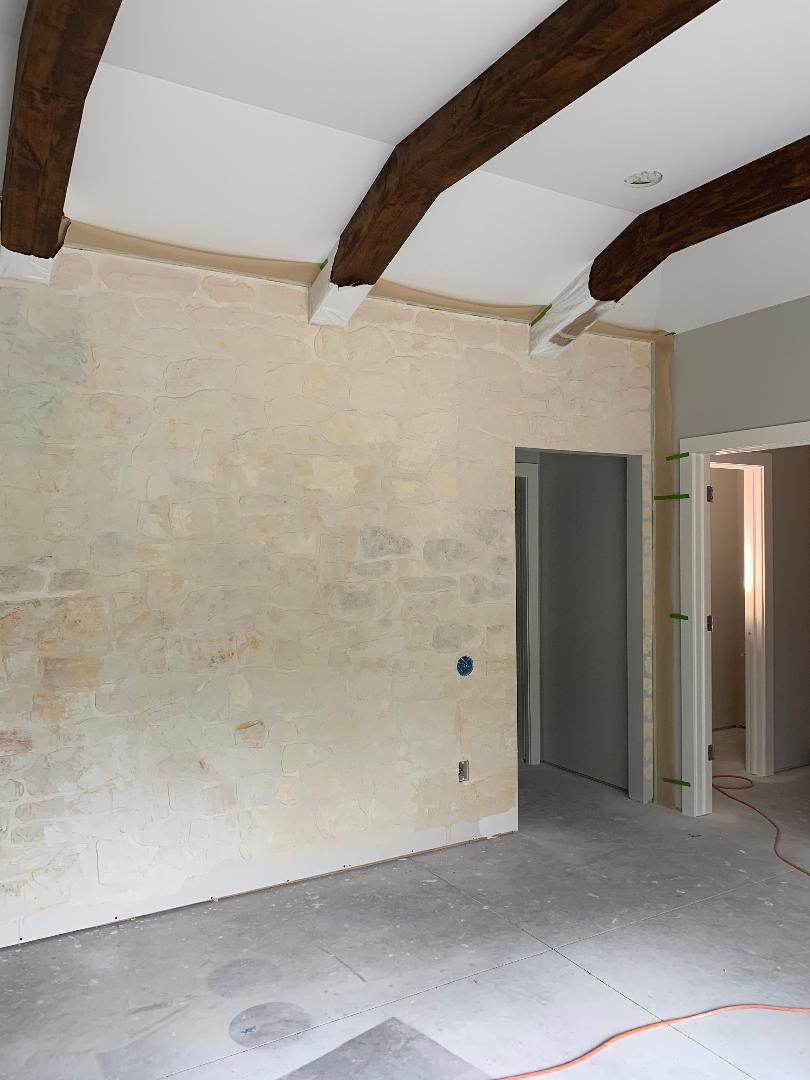 During the process of creating a DIY stone wall with The Detalles Stone Wall Stencil Kit.