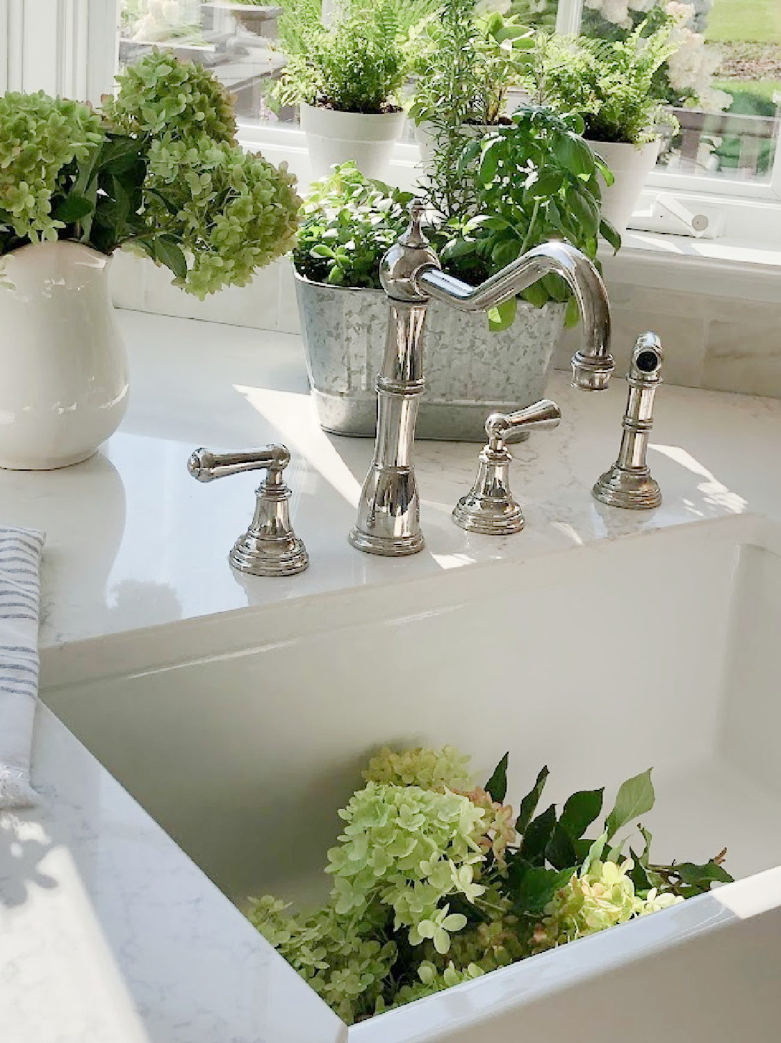 Hello Lovely's farm sink with Perrin & Rowe faucet and hydrangea from garden. Countertop is VIATERA Muse quartz.