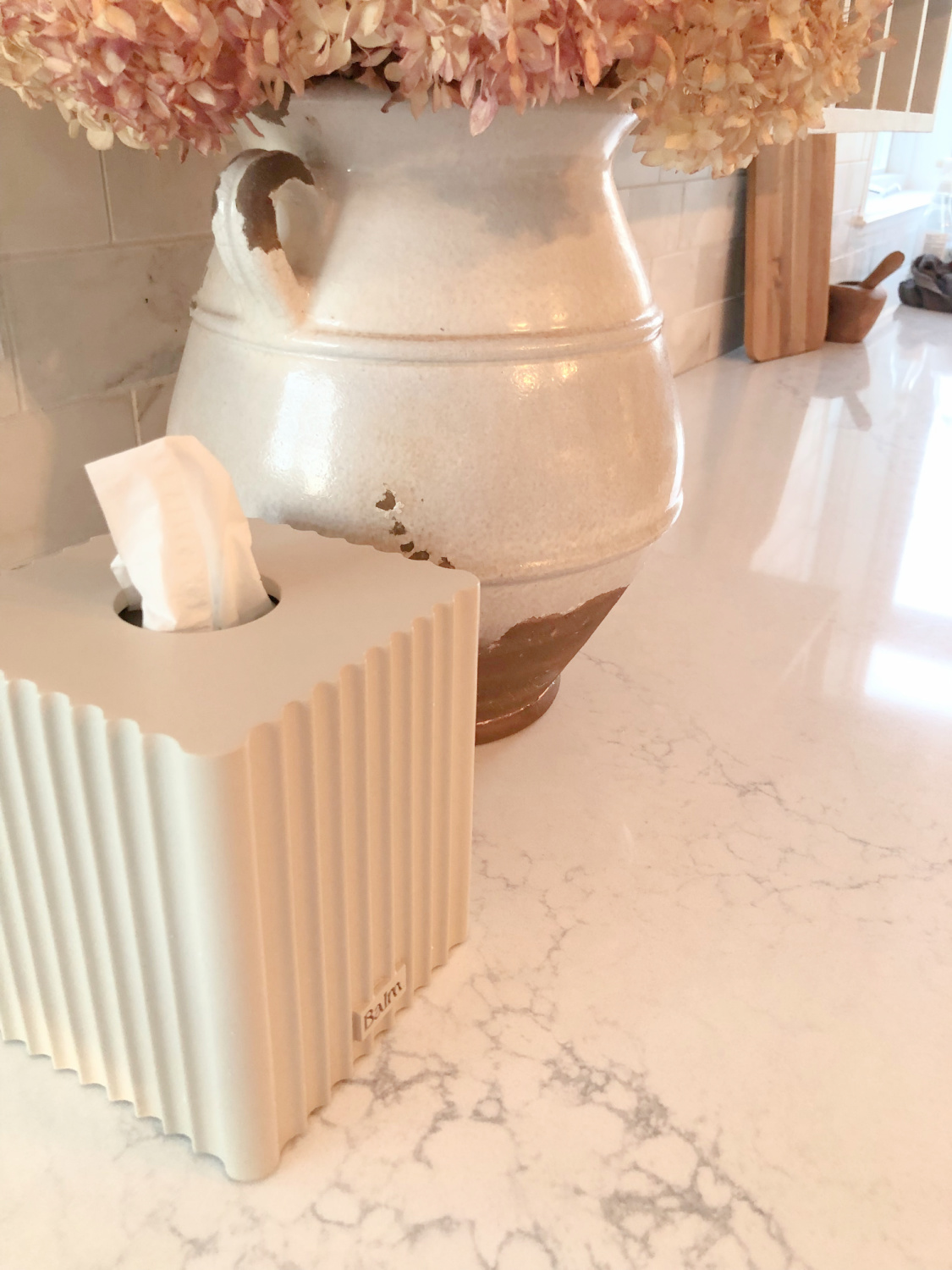 Hello Lovely's European country kitchen with gilded chandelier, Muse quartz counters (Viatera) and tissue box cover (The Balm Home).