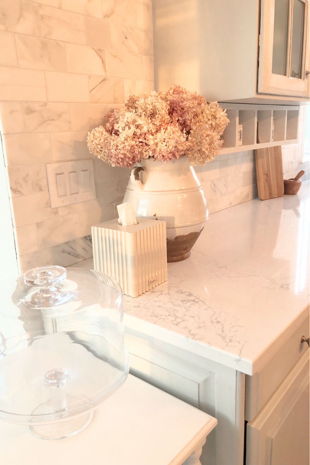 Hello Lovely's European country kitchen with gilded chandelier, Muse quartz counters (Viatera) and tissue box cover (The Balm Home).