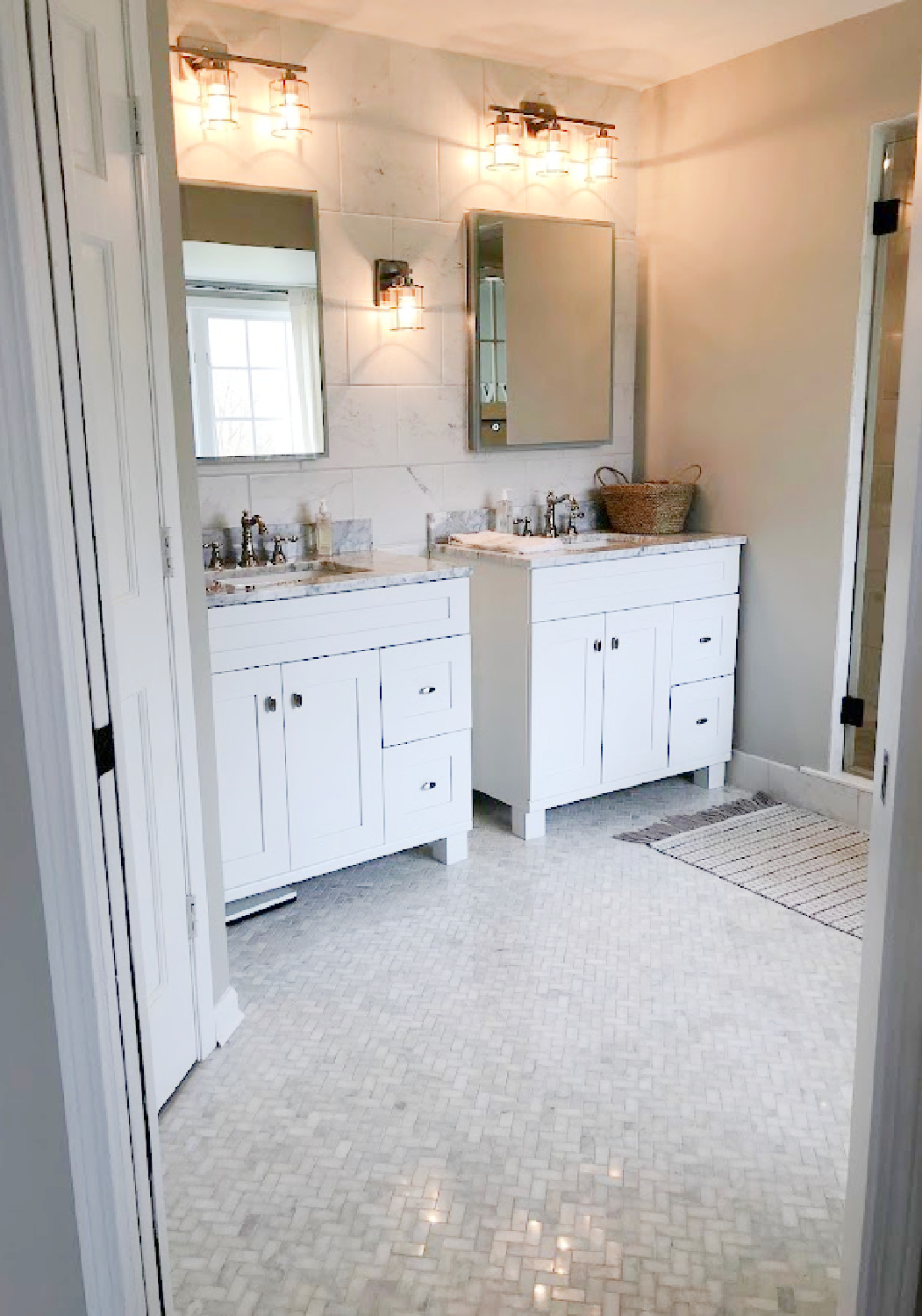 Hello Lovely's primary bath with vanities, marble herringbone tile floor, and SW Repose Gray on walls.