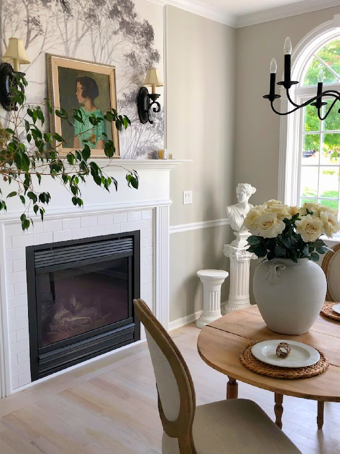 Hello Lovely's dining room with fireplace, wallpaper mural, and antique table. Wall color is SW Repose Gray.