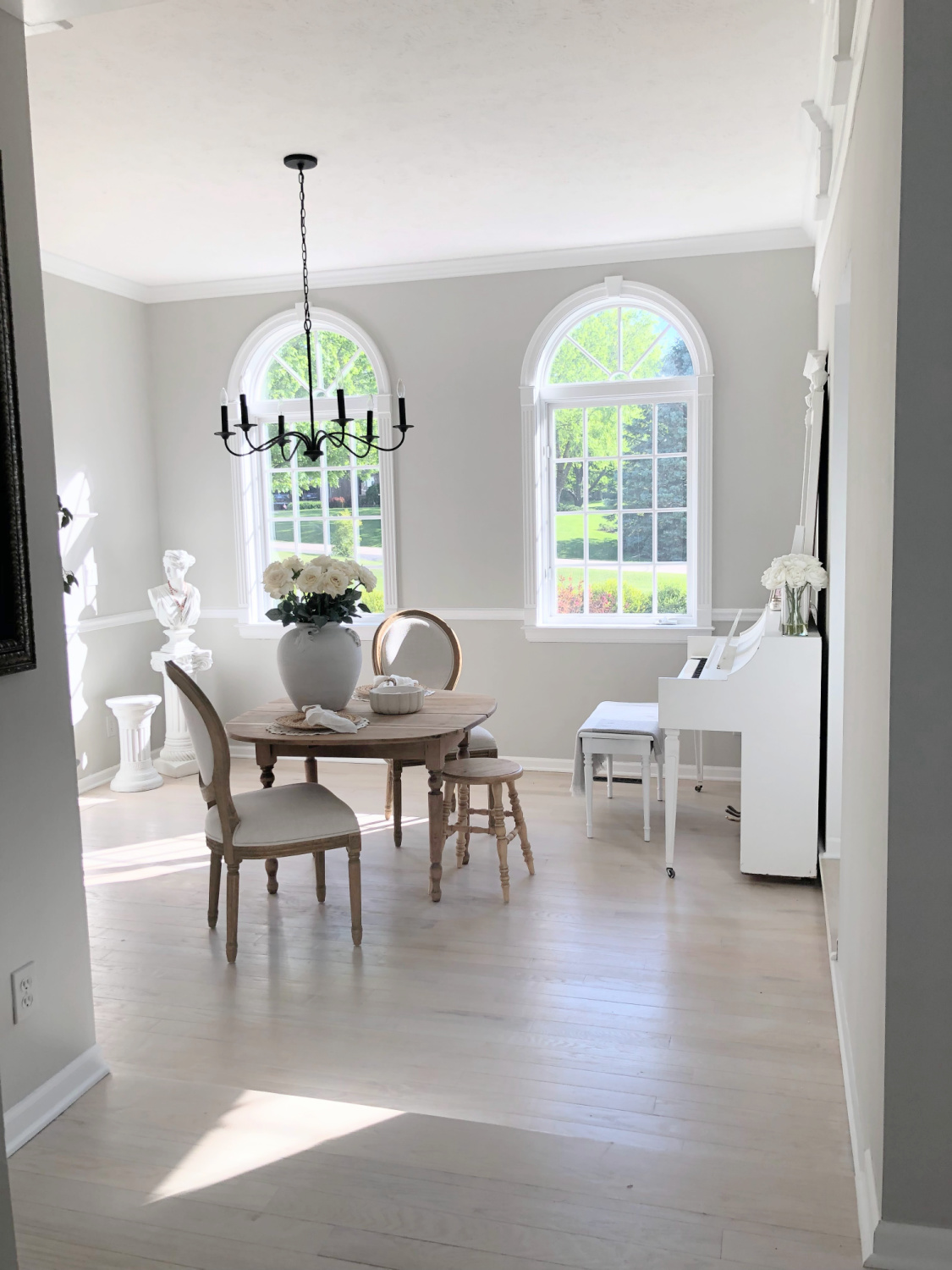 Hello Lovely's dining room with white piano and walls painted SW Repose Gray.