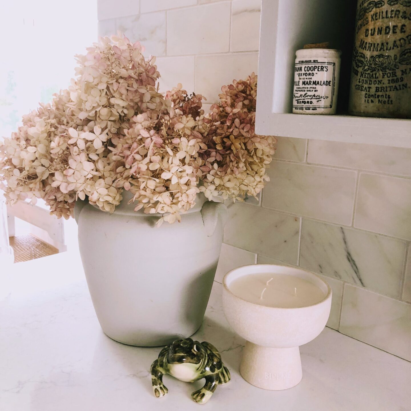 Hello Lovely's DIY renovated modern French kitchen with Viatera Muse quartz counters, calacatta marble backsplash, and Blueme candle (Calm).