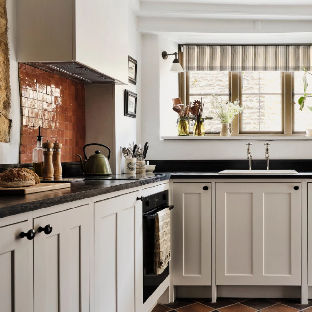 White English Country kitchen in Cotswolds stone cottage called Armada Cottage. It dates to 1489 with reimagined interiors by Beth Dadswell (Imperfect Interiors).