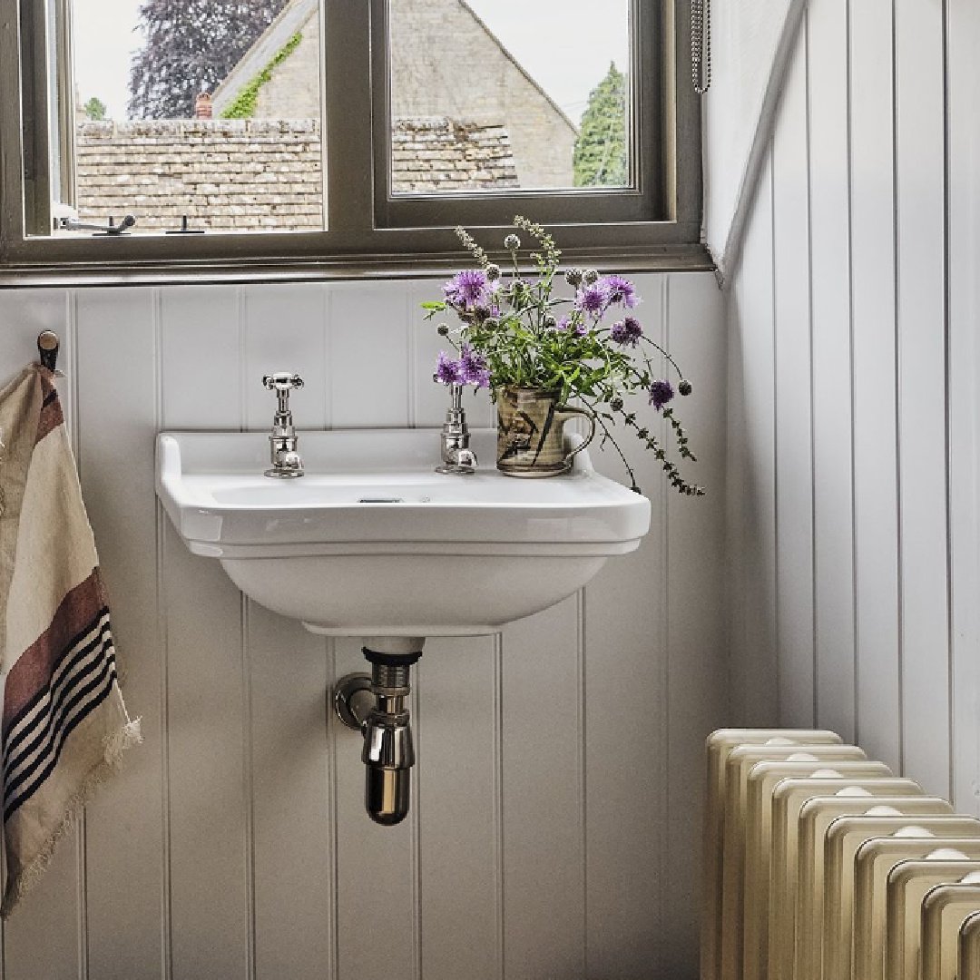 Charming bathroom sink and boarded walls in a Cotswolds stone cottage. Called Armada Cottage dates to 1489 with reimagined interiors by Beth Dadswell (Imperfect Interiors).