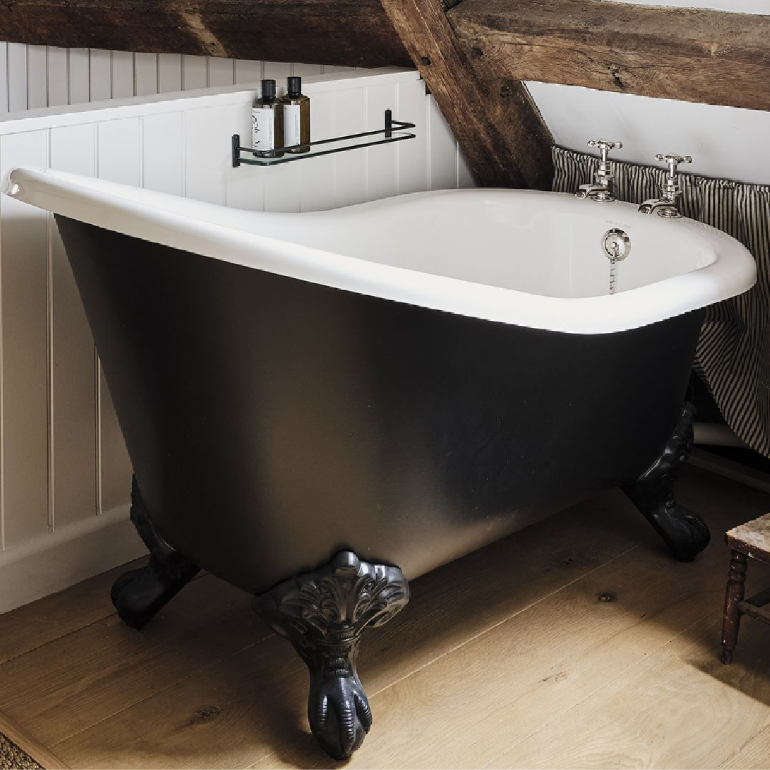 Charming soaking tube in a bedroom within a Cotswolds stone cottage. Called Armada Cottage, it dates to 1489 with reimagined interiors by Beth Dadswell (Imperfect Interiors).