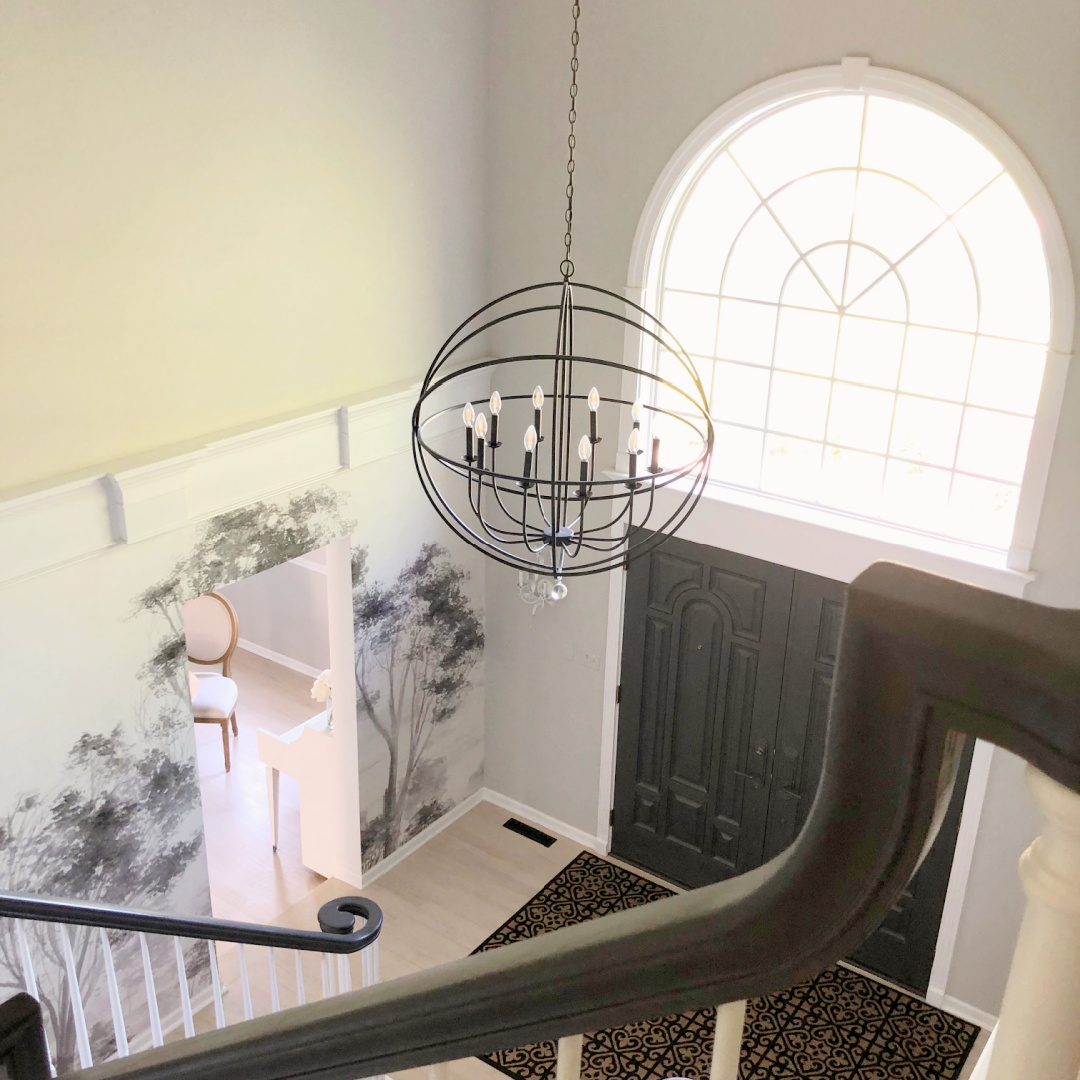 SW Repose Gray in Hello Lovely's two story foyer with mural wallpaper, modern orb chandelier and Farrow & Ball Railings painted front doors.