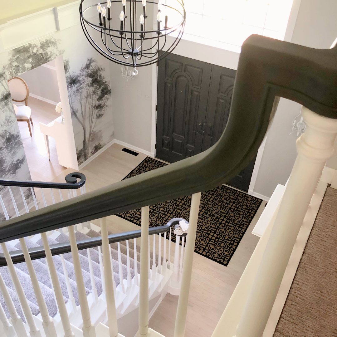 SW Repose Gray in Hello Lovely's two story foyer with mural wallpaper, modern orb chandelier and Farrow & Ball Railings painted front doors.