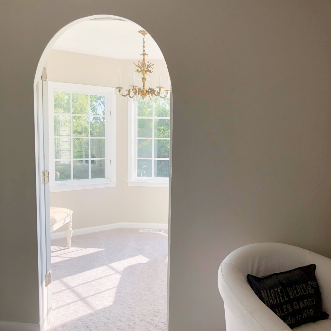 Hello Lovely's bedroom with turret sitting room, vintage chandelier and greige walls painted Sherwin-Williams Agreeable Gray.