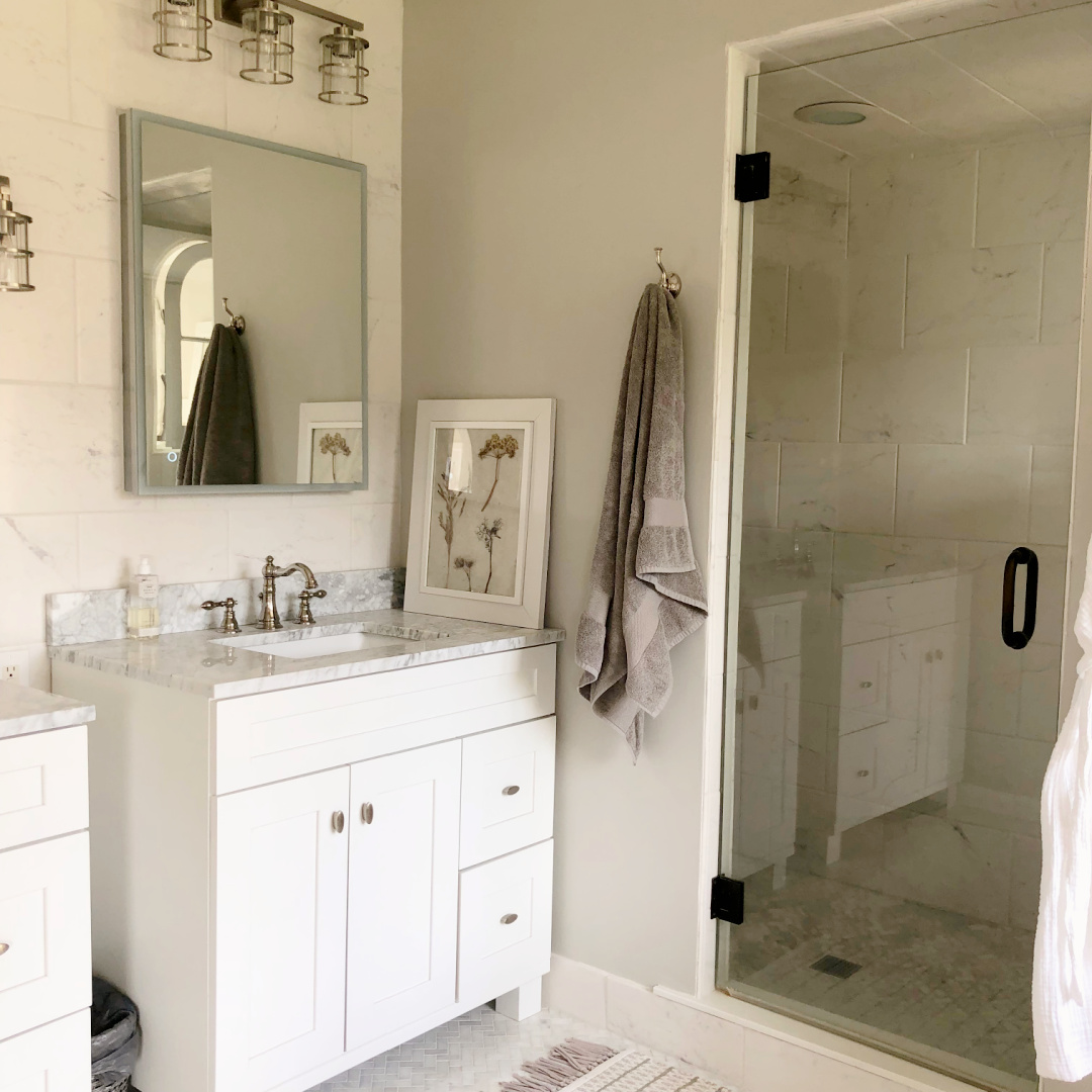 Hello Lovely's DIY renovated bath painted SW Repose Gray carrera marble topped vanities and with framed botanical print made by Michele.