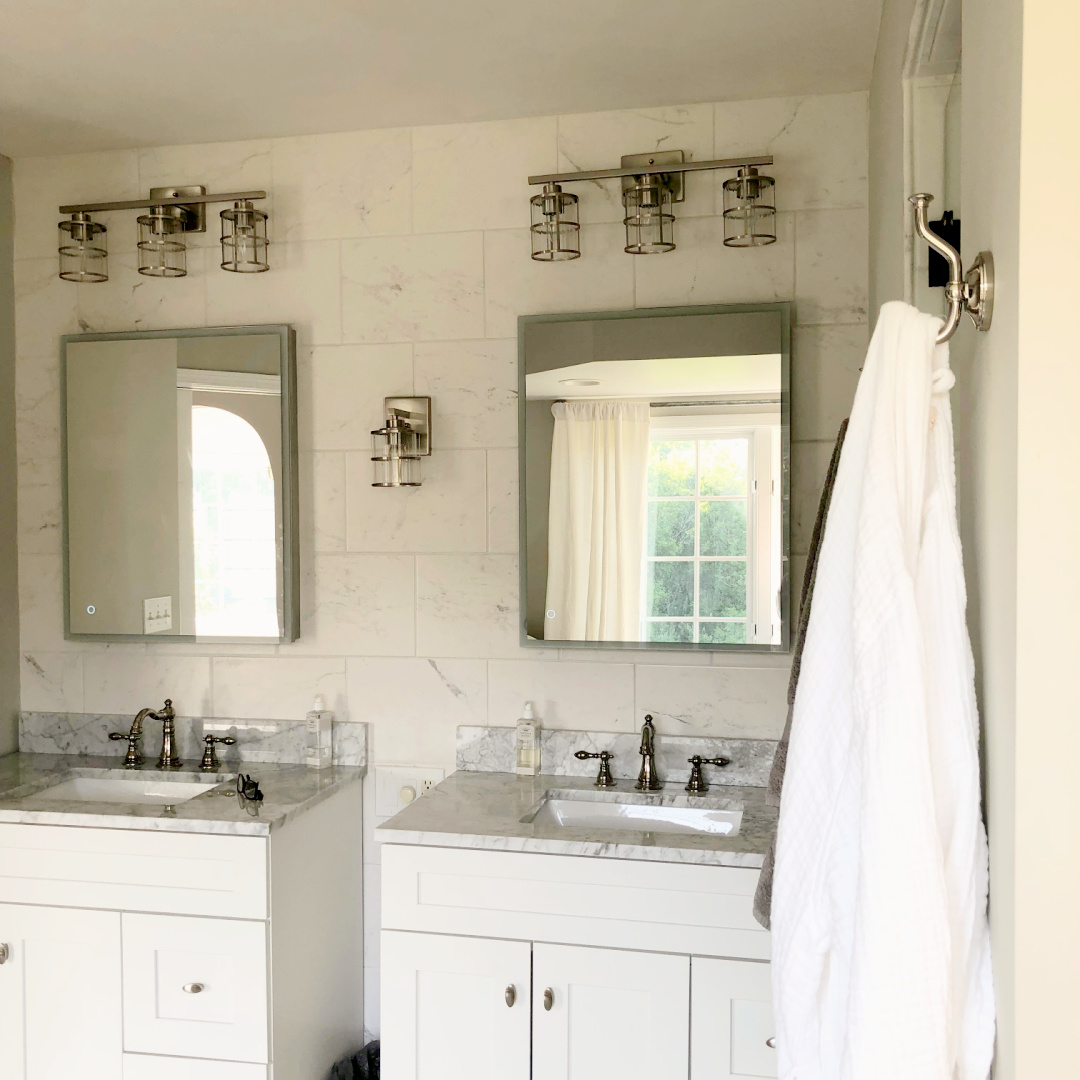 Hello Lovely's DIY renovated bath painted SW Repose Gray carrera marble topped Shaker style vanities.