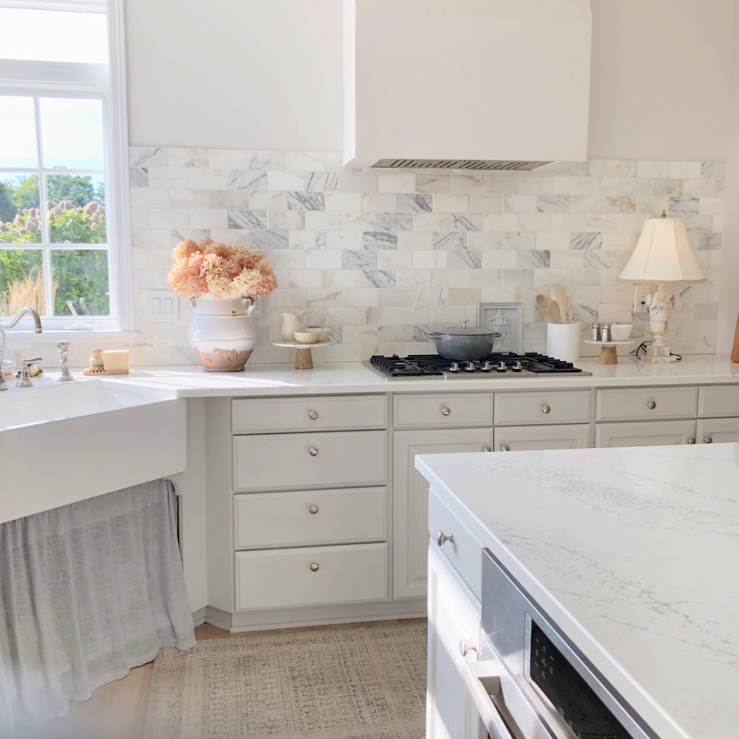 Hello Lovely's modern French kitchen with light grey cabinets and skirted sink.