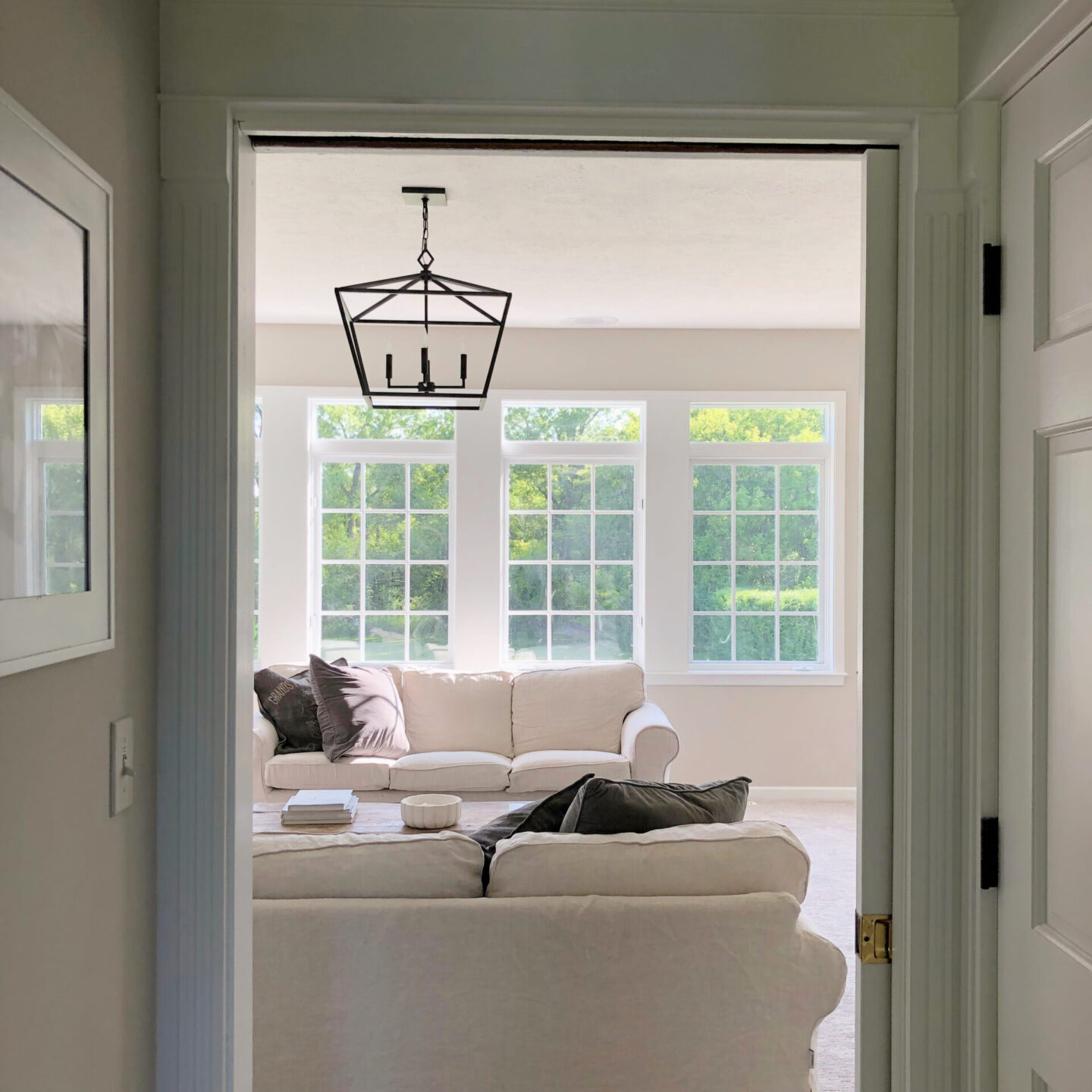 Hello Lovely's family room with Belgian linen sofas, beautiful forest view and pocket door.
