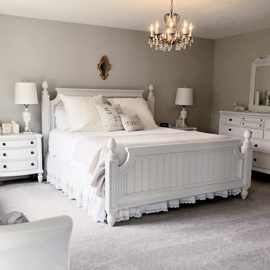 Hello Lovely's bedroom with coastal beadboard furniture, vintage chandelier and greige walls painted Sherwin-Williams Agreeable Gray.