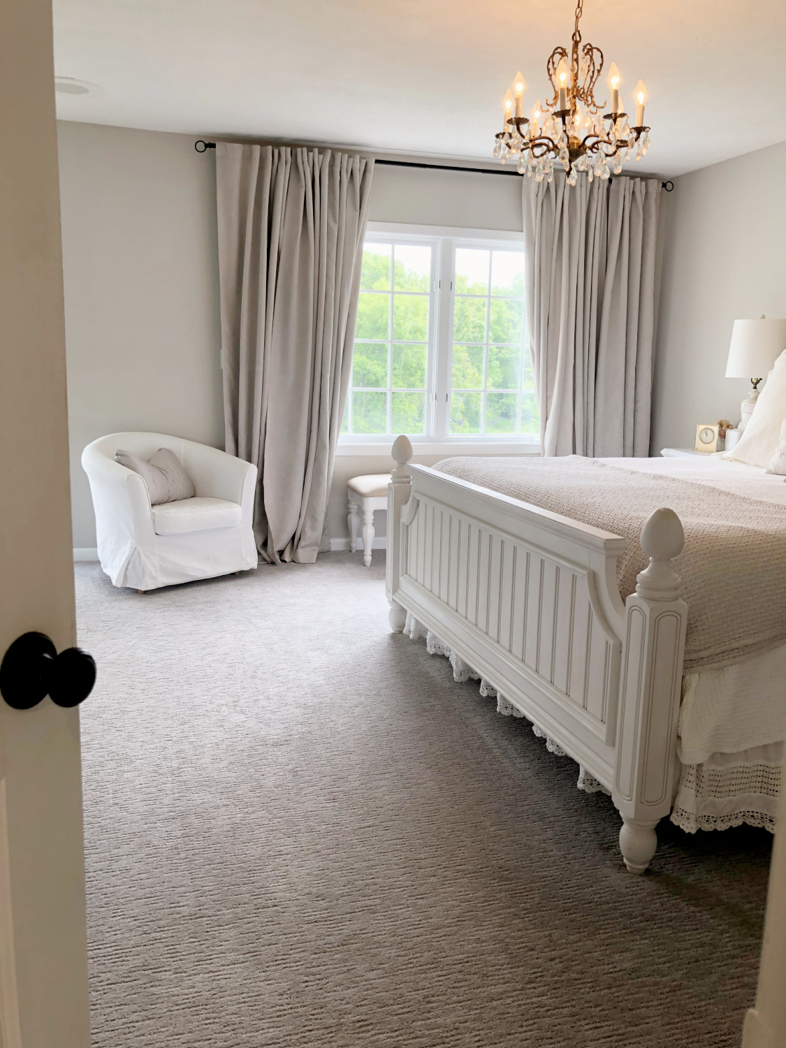 Hello Lovely's bedroom with coastal beadboard furniture, vintage chandelier and greige walls painted Sherwin-Williams Agreeable Gray.