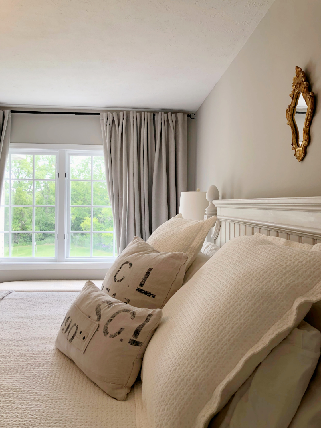 Hello Lovely's primary bedroom is serene and greiege with a beautiful view and SW Agreeable Gray walls.