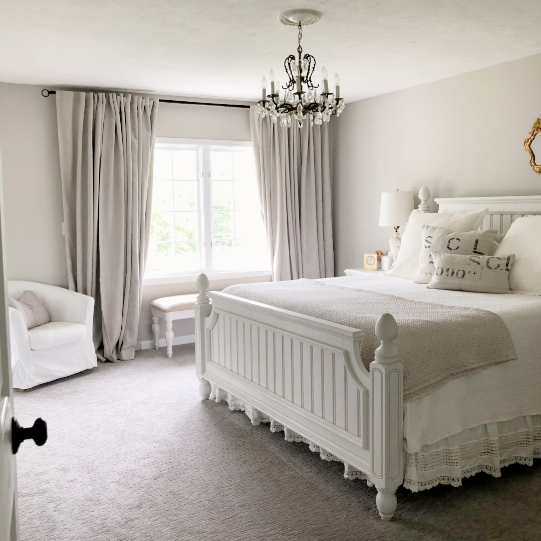 Hello Lovely's bedroom with coastal beadboard furniture, vintage chandelier and greige walls painted Sherwin-Williams Agreeable Gray.