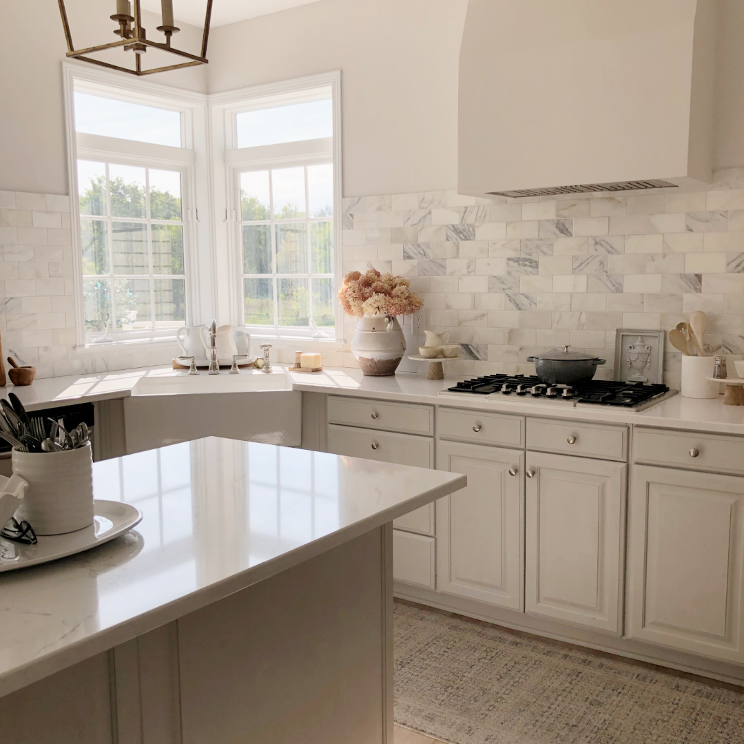 Hello Lovely's modern French serene white kitchen with corner sink and calacatta gold marble.