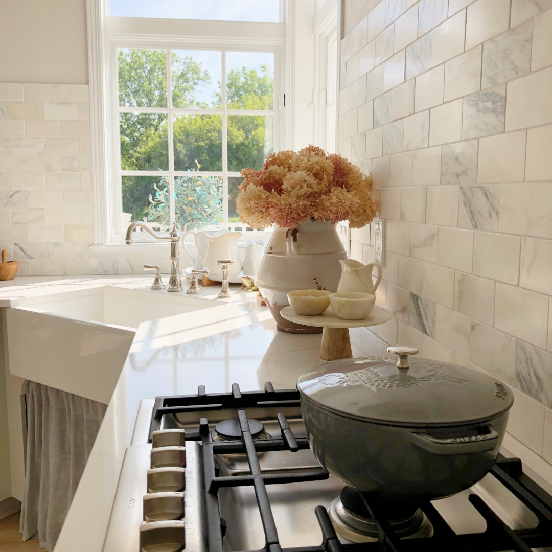Hello Lovely's modern French serene white kitchen with corner sink and calacatta gold marble.