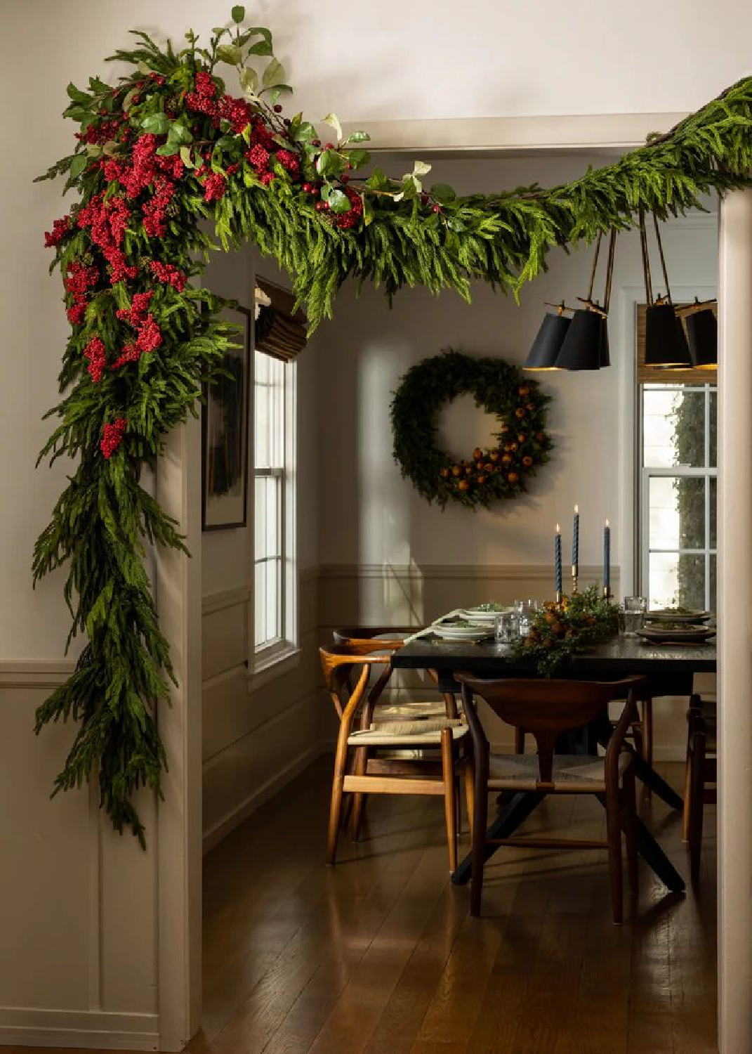 Beautiful swagged holiday greenery and wreath in a cozy holiday dining room - Afloral. #holidaygreenery #holidaydecor
