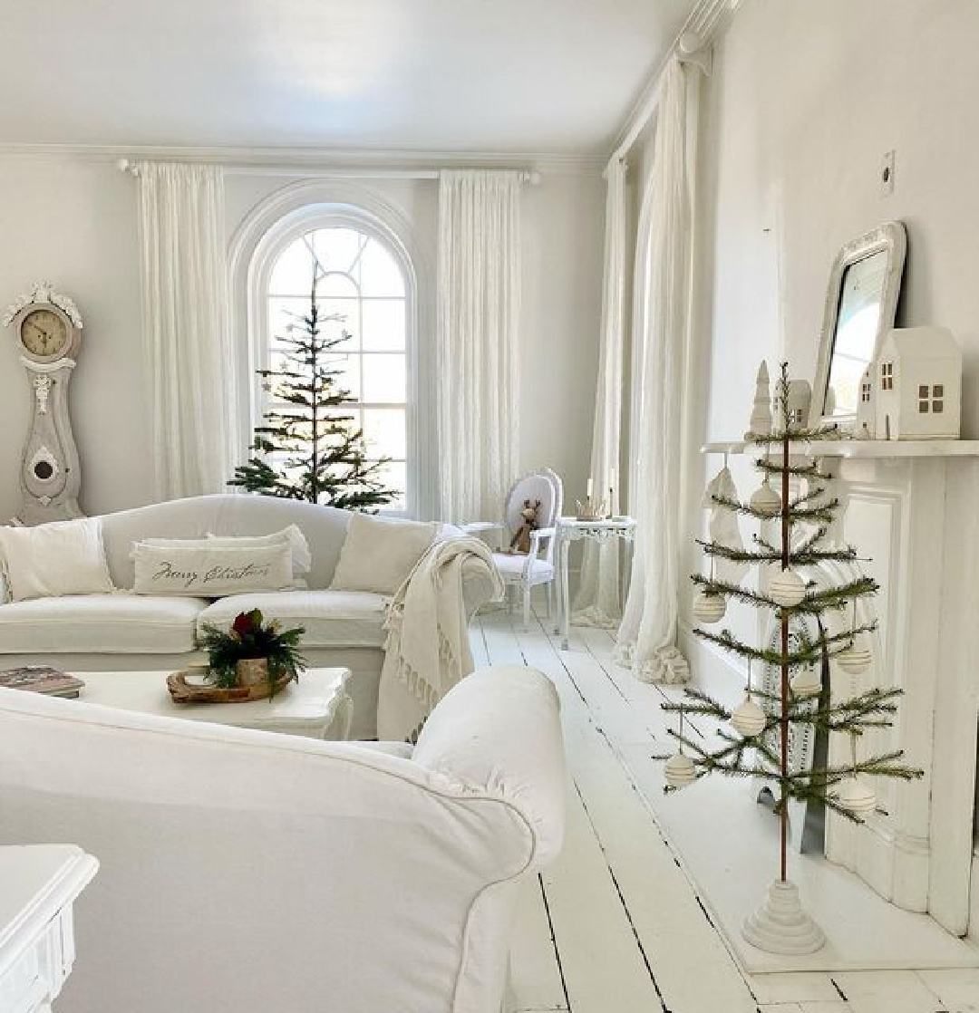 Beautiful white Scandi Christmas living room with white wood floor and tone on tone holiday decor - Lavender Flower Studio. #scandichristmas #whitechristmasdecor
