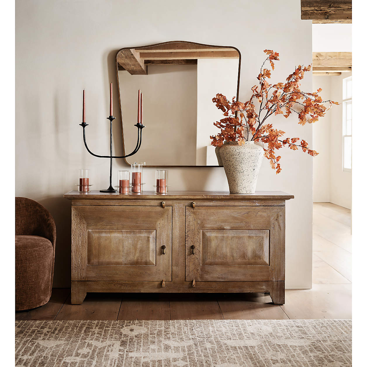 Maloy Black Metal Trident Candelabra (Crate & Barrel) on a rustic wood sideboard with fall florals.