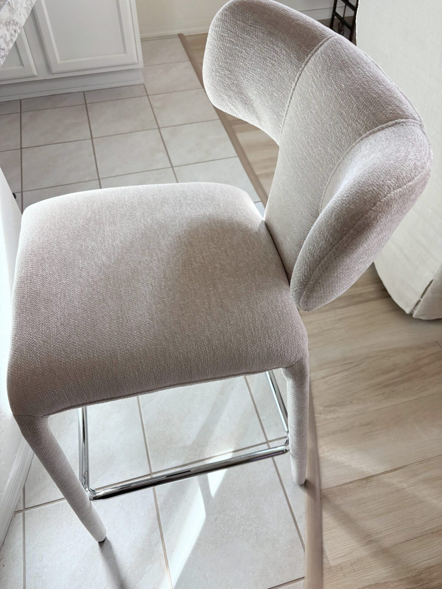 Modern Scandi-style beige upholstered counter stool in Hello Lovely's snowbird sanctuary. #counterstools