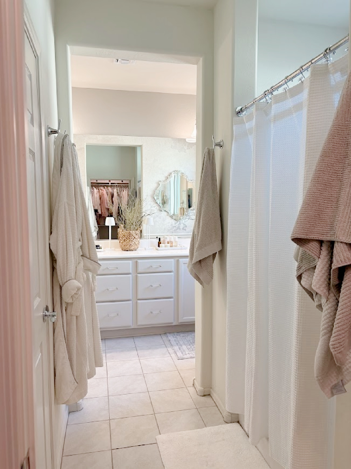 Our renovated bath at the snowbird Arizona house with SW Agreeable Gray painted vanity, lucite hardware, Venetian mirrors layered on a Photowall mural wallpaper, and rugs from Loloi x Amber Lewis - Hello Lovely Studio.