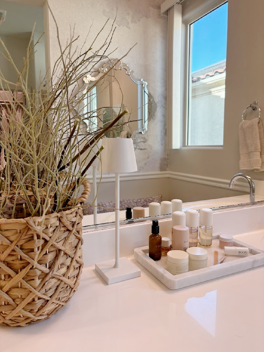 Our renovated bath at the snowbird Arizona house with SW Agreeable Gray painted vanity, lucite hardware, Venetian mirrors layered on a Photowall mural wallpaper, and rugs from Loloi x Amber Lewis - Hello Lovely Studio.